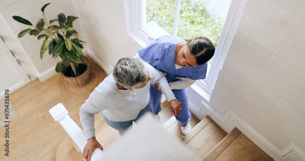 nurse helping woman get up the stair