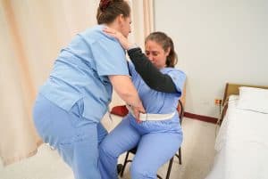 home health aide helping an elderly woman