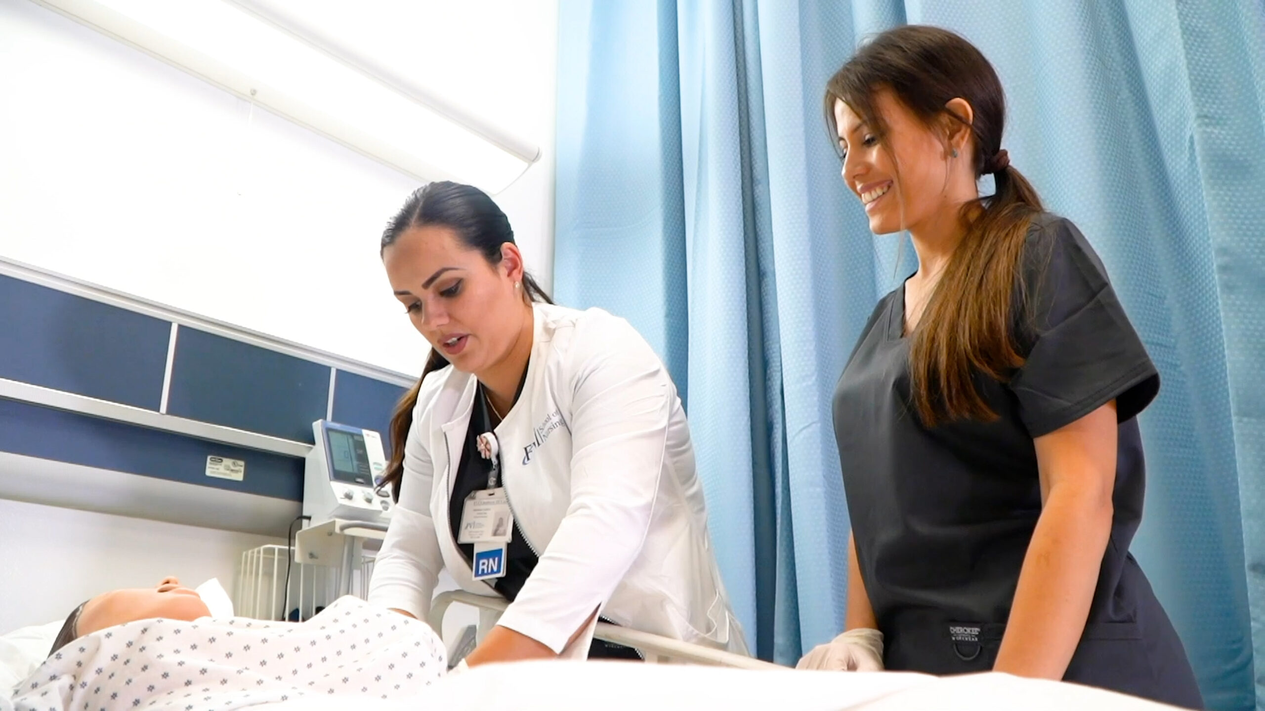 An FVI instructor demonstrates a medical procedure while a nursing student observes