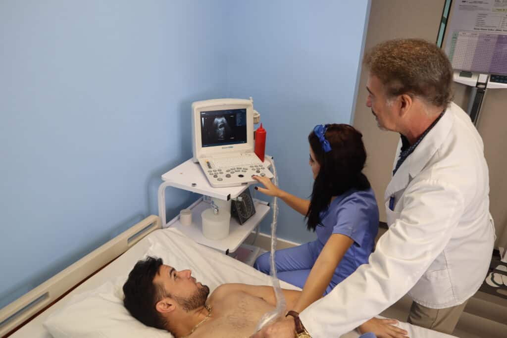An FVI instructor assists a student with performing a basic medical test on another student