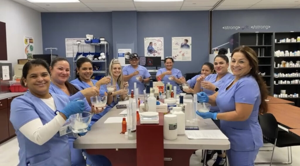 pharmacy students smiling at the camera while they practice