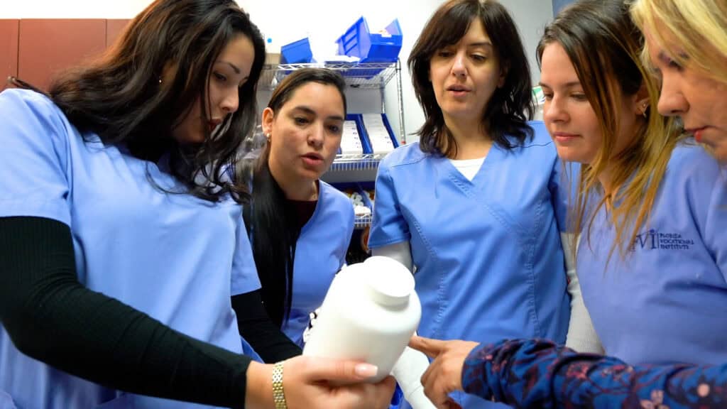students gathered together looking at pills