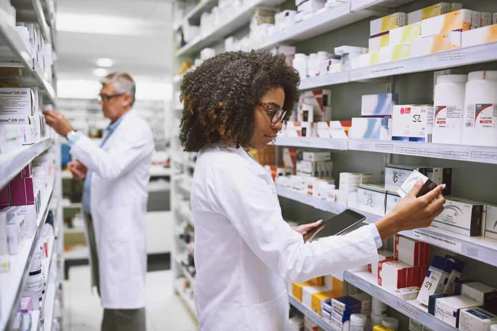 Shot of two focused pharmacist walking around and doing stock inside of a pharmacy