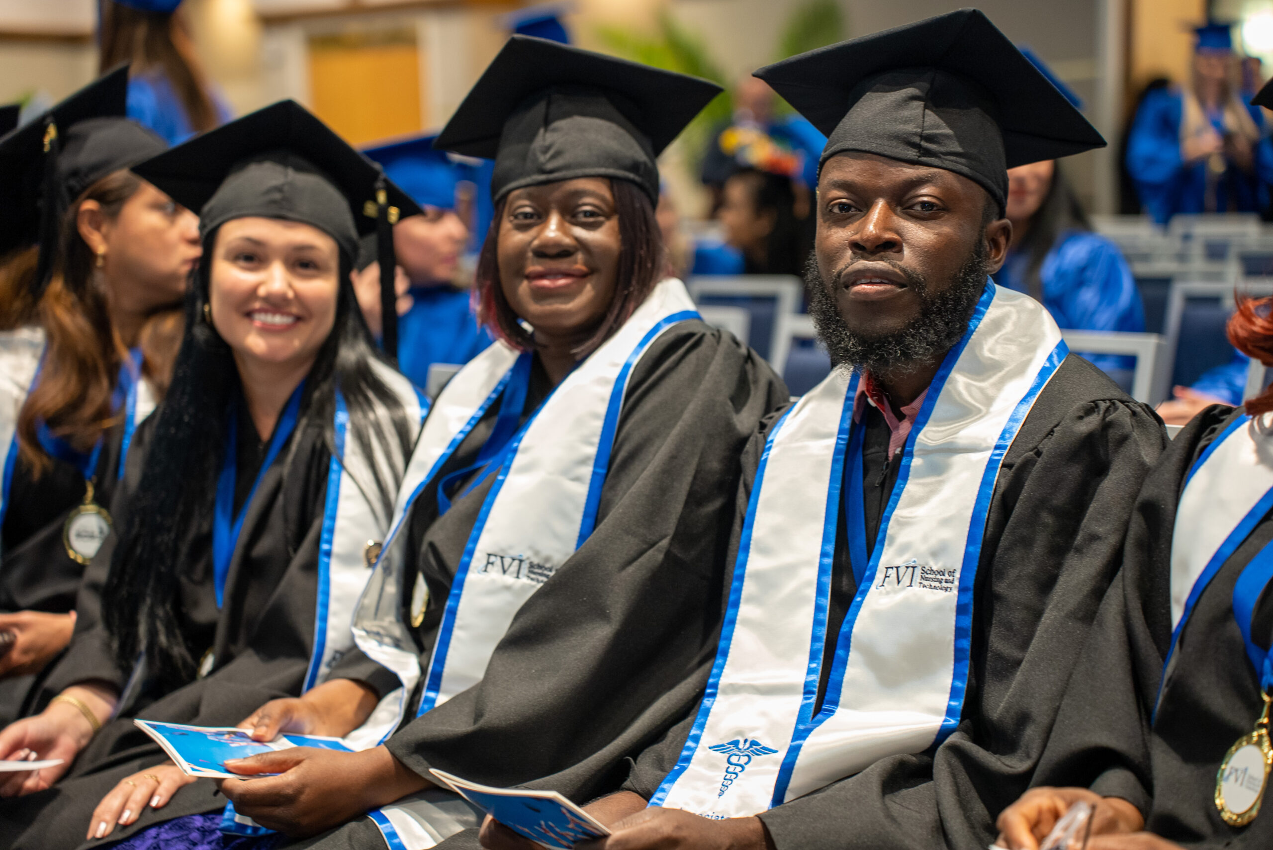 A group of Nursing graduates sitting at an FVI graduation ceremony in their robes with their FVI stoles