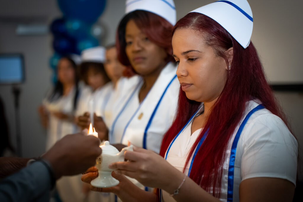 nursing graduate lighting her candle during the pinning ceremony