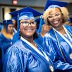 2 graduates smiling at an FVI graduation