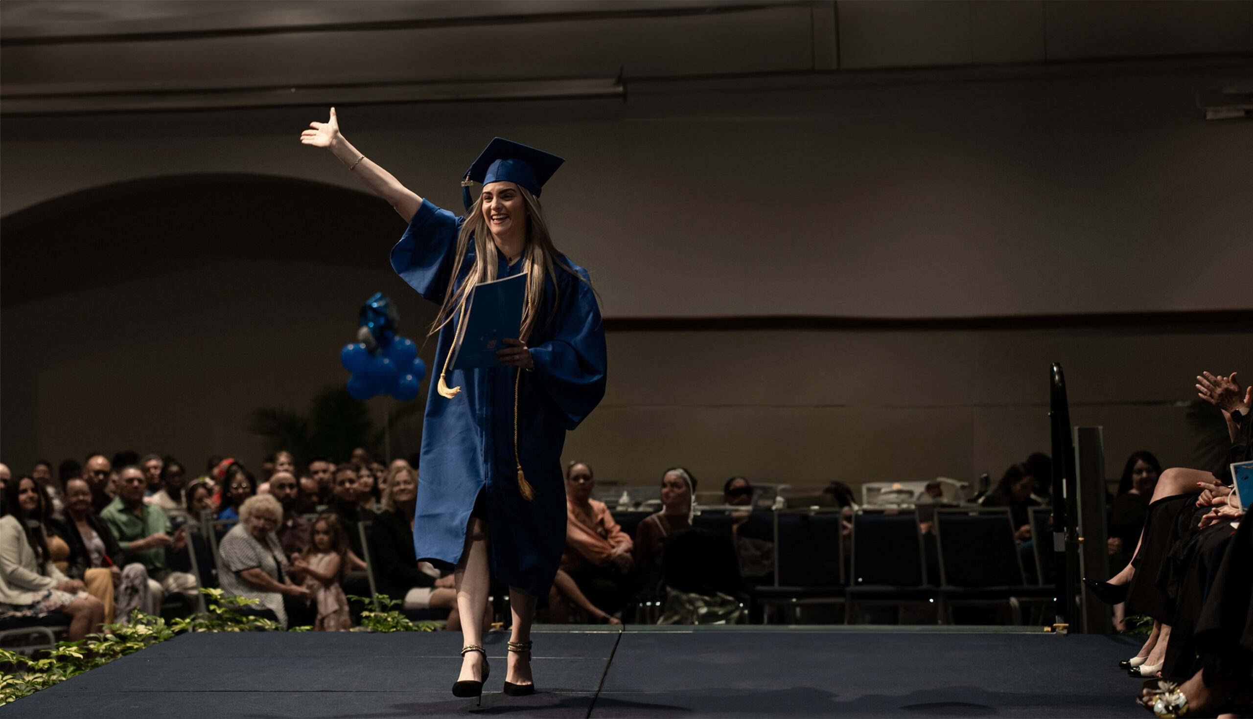 An excited FVI graduate walking across the stage a graduation