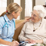 home health aide working with elderly woman