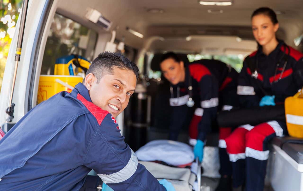 EMT team assisting with patient transport in ambulance