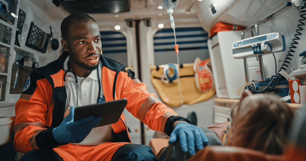 EMT reviewing patient data on a tablet inside ambulance