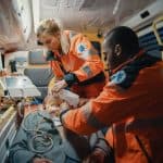 EMT student smiling inside a well-equipped ambulance