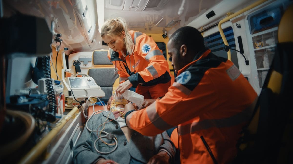 EMT student smiling inside a well-equipped ambulance